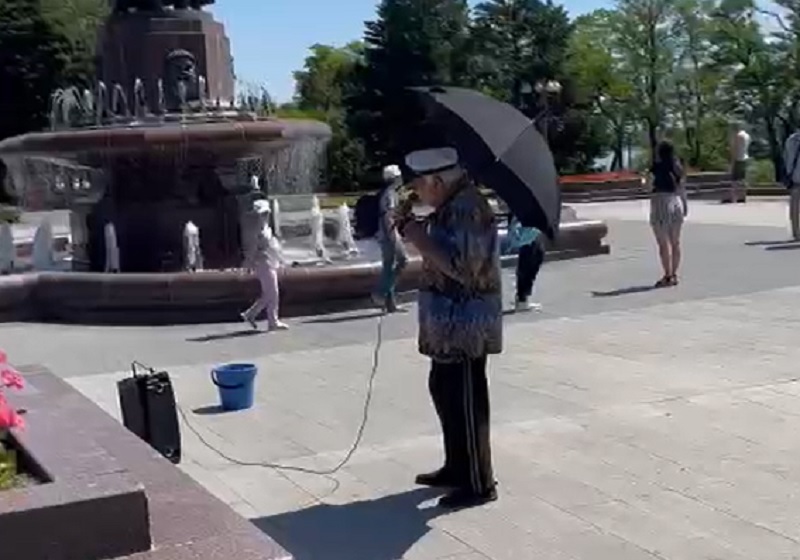 Пенсионеры выживают, как могут: в жару волгоградец с черным зонтиком вышел петь песни за гонорар